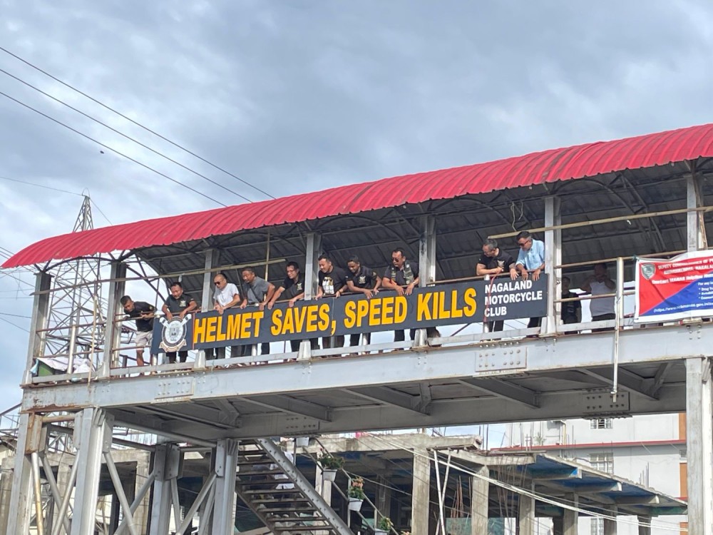 NMC members installing reflective road safety signs at the foot overbridge at the Chümoukedima second gate, NH 29, on July 2. (Morung Photo)